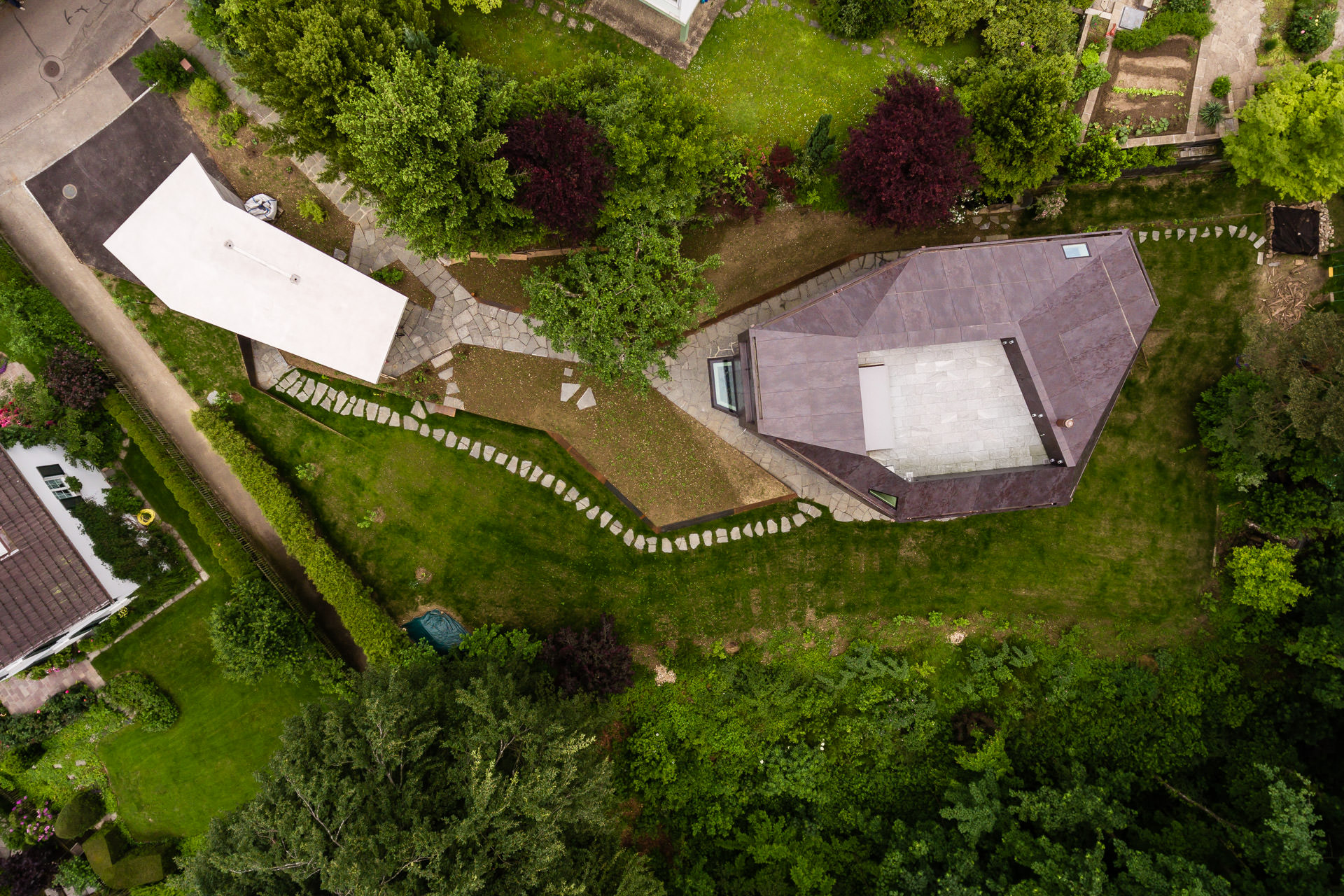 Drone view down to Casa Forest and it's unique garden design and garage building.