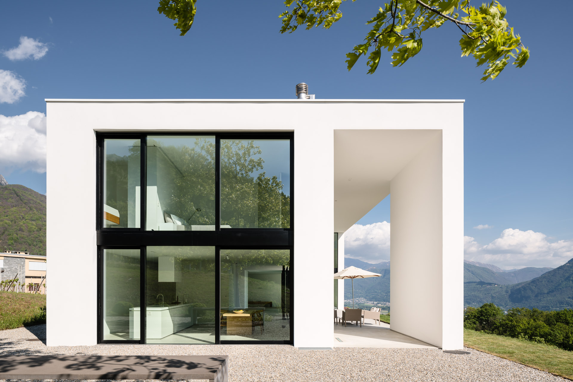 Architectural photo of vacation house Casa Nik in Ticino with view into kitchen, bedroom and to the terasse.