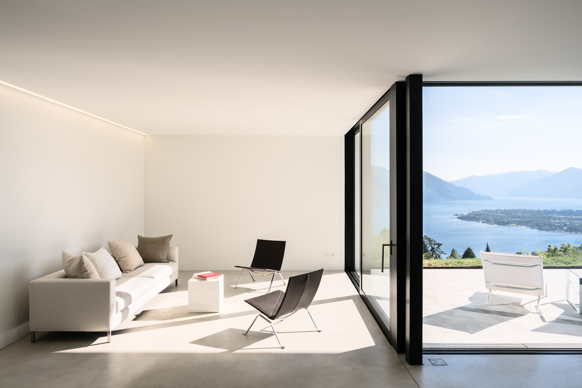 Living room and terrace with a view in Casa Nik. Photo by architectural photographer Philippe Wiget. Architecture: Daluz Gonzalez & Cajos Architects