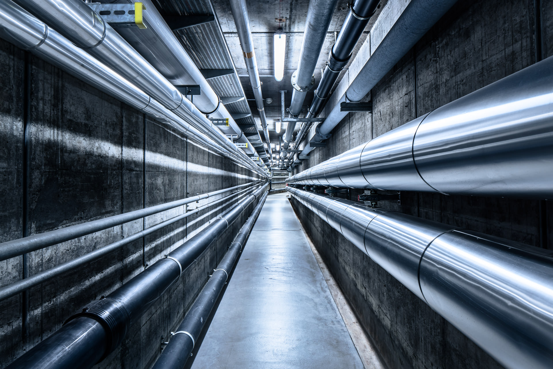 Key visual und Bildwelten: Röhren und Zentralperspektiven in unterirdischer Industrieanlage. Industriefotografie Philippe Wiget
