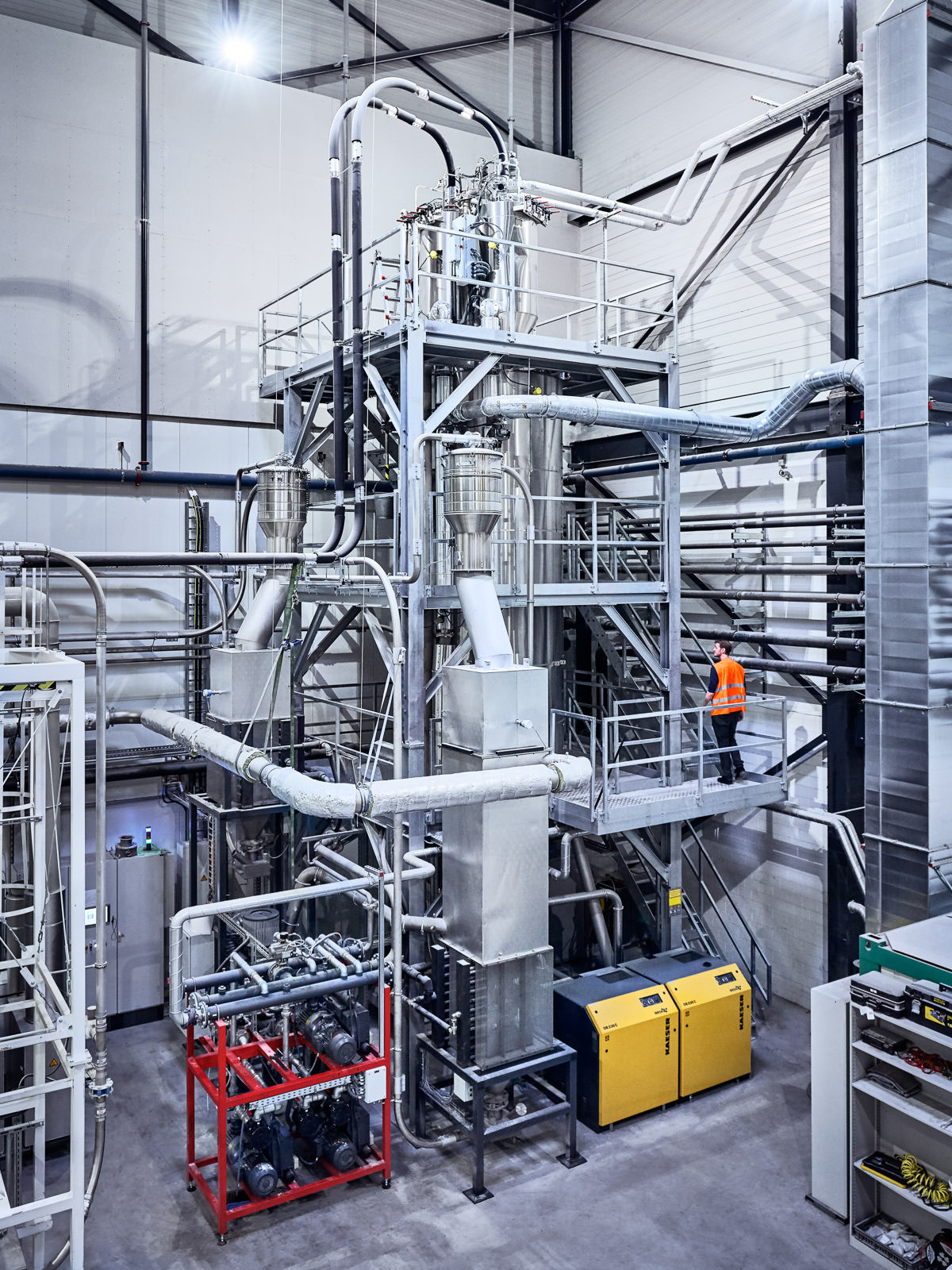Industrial plant spanning over 10+m height with a man at work - Corporate Reportage & Documentary